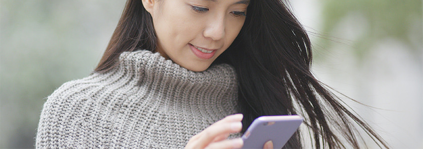 Woman  in sweater looking at cell phone
